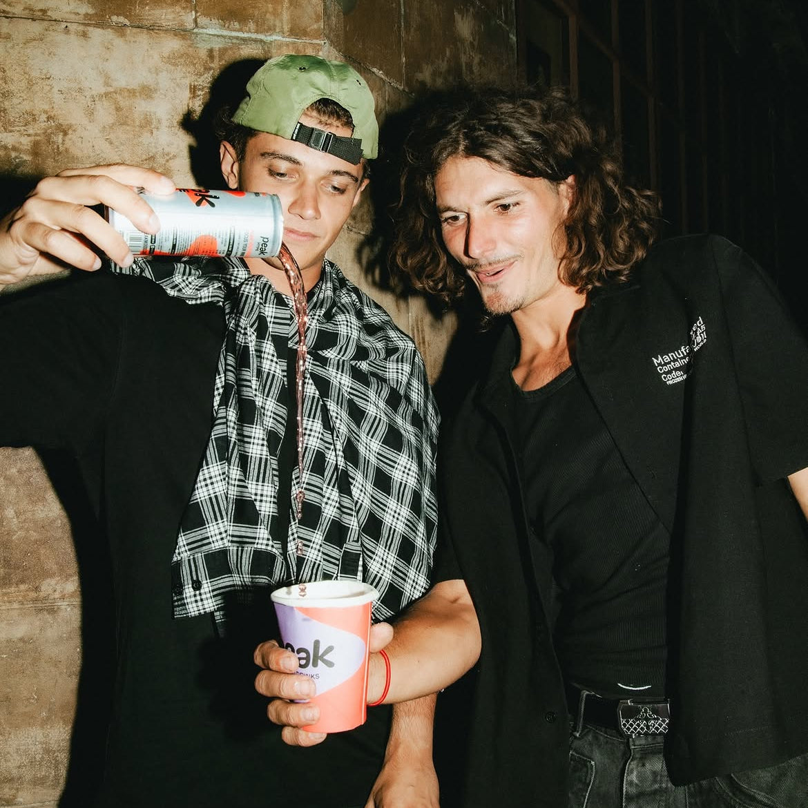 Friends sharing a can of Peak Hype on a night out